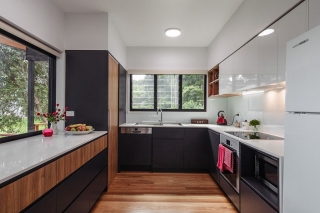 Дизайн кухни с двумя окнами, объединенными одной столешницей